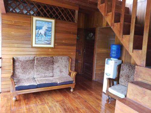 a living room with a couch and a picture of a horse at QUINTA PRIMAVERA - Hostería Campestre in Nueva Loja