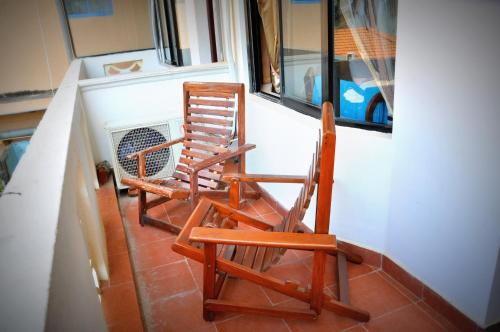 two rocking chairs sitting in front of a window at Blumarine Guest House in Negombo