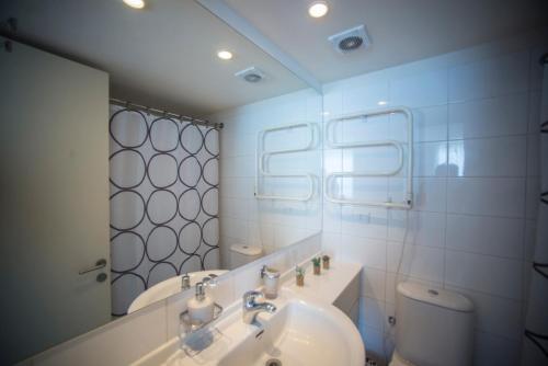 a bathroom with a sink and a toilet and a mirror at San Alfonso Del Mar Apartment in Algarrobo