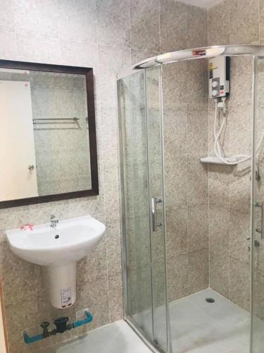 a bathroom with a sink and a glass shower at BP Grand Hotel in Chiang Mai