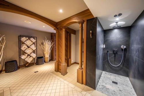 a bathroom with a shower and a tiled floor at Hotel Allodis in Méribel