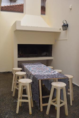 a table with four stools in a room with a fireplace at Central Paz Hostel in Villa Carlos Paz