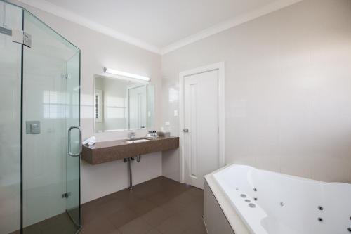 a bathroom with a tub, sink, and shower at The Barn Accommodation in Mount Gambier