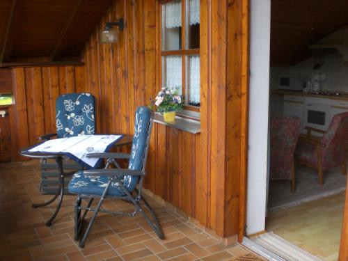 eine Veranda mit einem Tisch und Stühlen sowie eine Küche in der Unterkunft Ferienwohnungen Winter in Lohberg
