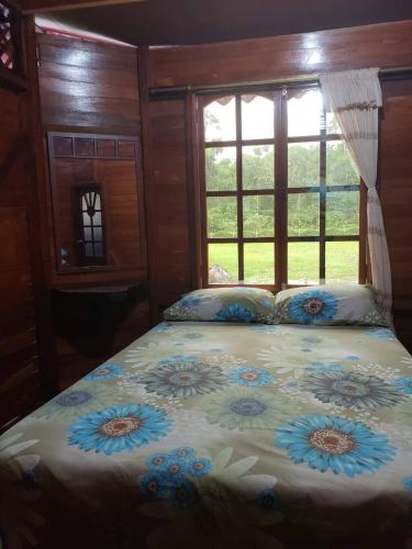 a bedroom with a bed with blue flowers on it at QUINTA PRIMAVERA - Hostería Campestre in Nueva Loja
