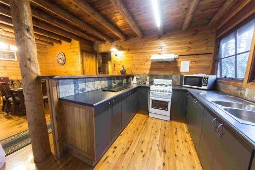 una cucina con pareti in legno e pavimenti in legno di Springbrook Mountain Chalets a Springbrook