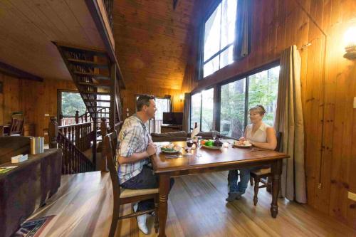 a man and woman sitting at a table in a restaurant at Springbrook Mountain Chalets in Springbrook