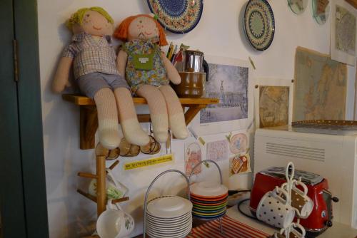 two dolls sitting on a shelf in a kitchen at The House Hostel in Sokcho