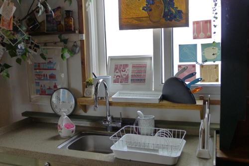 a kitchen counter with a sink and a window at The House Hostel in Sokcho