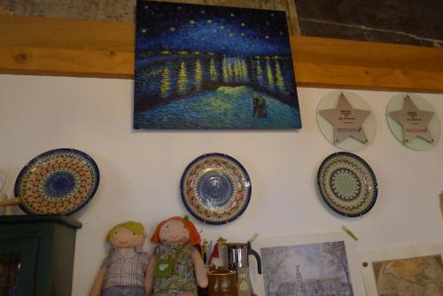 two dolls and plates on a wall with a painting at The House Hostel in Sokcho