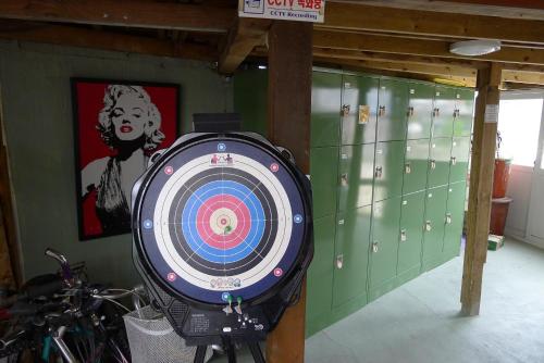a dart board in a locker room with a picture of a woman at The House Hostel in Sokcho