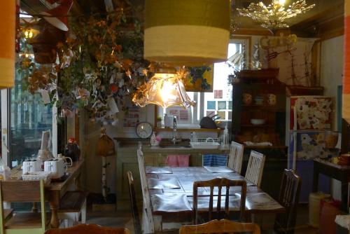 a dining room with a table and a kitchen at The House Hostel in Sokcho