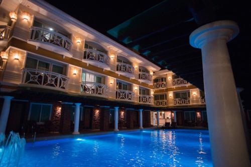 a hotel with a large swimming pool at night at Boracay Mandarin Island Hotel in Boracay