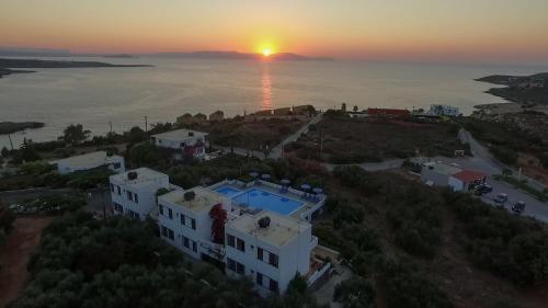 an aerial view of a house with the sunset in the background at Villas Michalis in Chorafakia