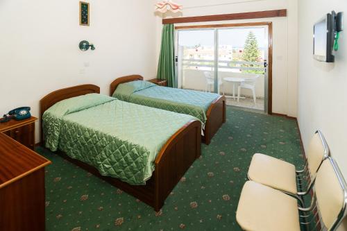 a hotel room with two beds and a balcony at Marion Hotel in Polis Chrysochous