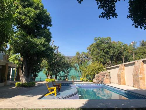 a swimming pool with a yellow chair next to a building at Rinconada Hotel Boutique in Iguala de la Independencia