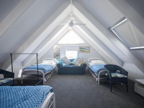 a attic room with four beds and a window at Twin Peaks 1 in Blueys Beach