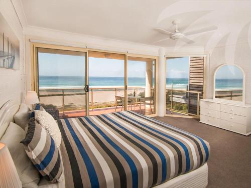 a bedroom with a bed and a view of the ocean at Allure on Blueys in Blueys Beach