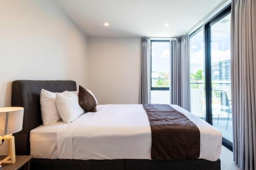 a bedroom with a bed and a large window at The Edgerley Suites in Auckland