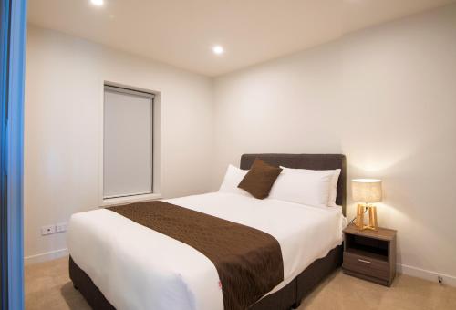a bedroom with a large bed and a window at The Edgerley Suites in Auckland