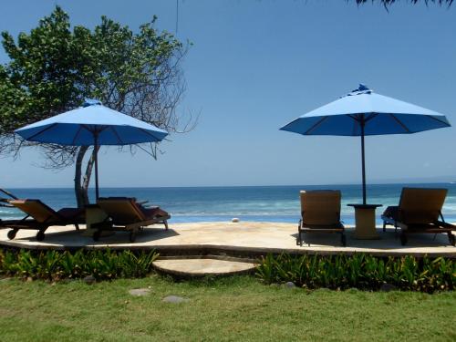 a group of chairs and umbrellas on the beach at Jasri Bay Hideaway in Jasri