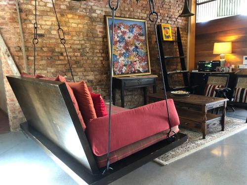 a couch swing hanging from a brick wall at Spices Hotel in George Town