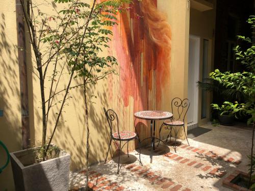 two chairs and a table in front of a wall at Spices Hotel in George Town