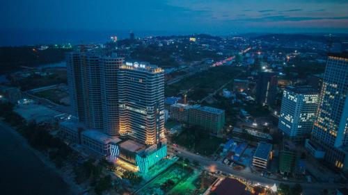 Jing Shang Hotel في سيهانوكفيل: مدينة مضاءة ليلا مع مباني طويلة