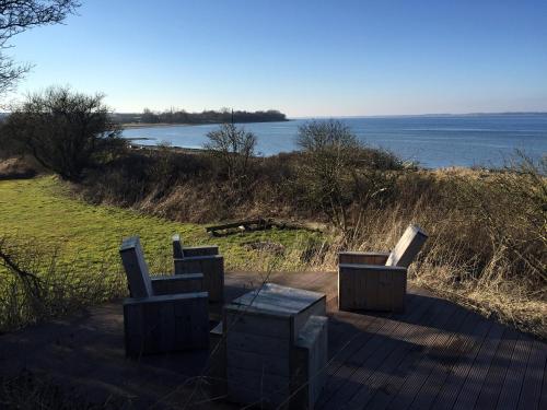 a deck with chairs and a table and a view of the water at Landhaus Habernis in Steinberg