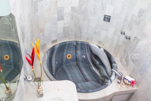 a bath tub in a bathroom with a sink at Hotel La Alondra in Barra de Navidad