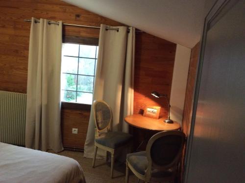 a bedroom with a desk and a bed and a window at annexe du Mesnil in Le Tourne