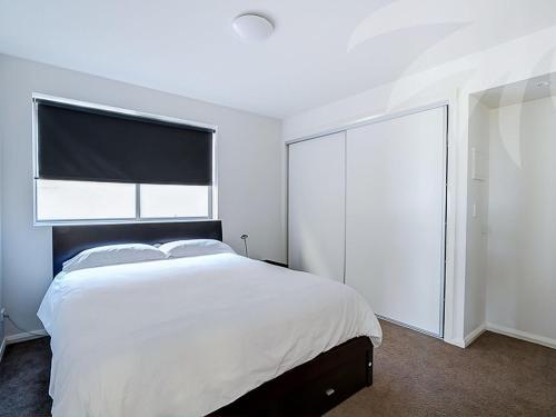 a white bedroom with a large bed and a window at Blueys Bliss 2 in Blueys Beach