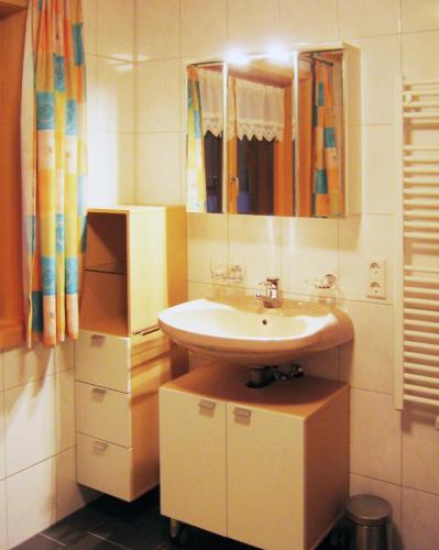 a bathroom with a sink and a mirror at Apart Greber in Andelsbuch