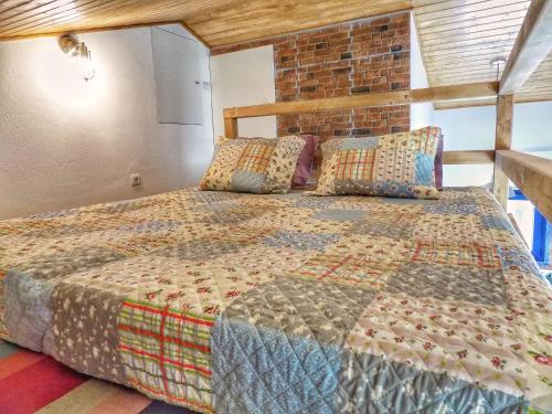 un grande letto in una stanza con un muro di mattoni di Villa Peponi a Ericeira