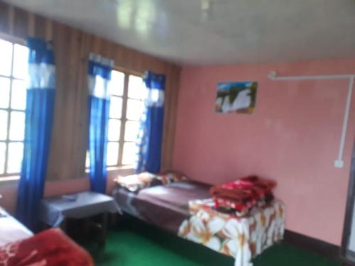 a bedroom with a bed and a table and windows at Vamoose Anugraha in Mangpu