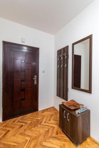 a room with a wooden door and a mirror at HOUSE OF SURPRISE in Užice