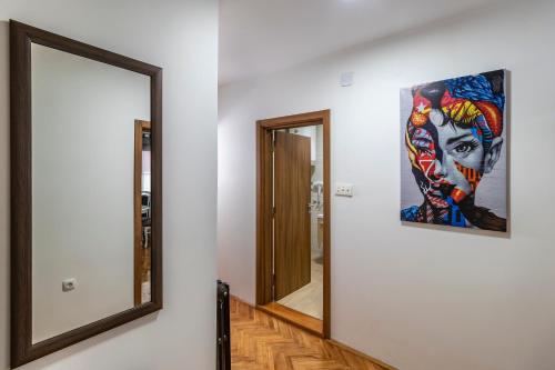 a mirror in a hallway with a painting on the wall at HOUSE OF SURPRISE in Užice
