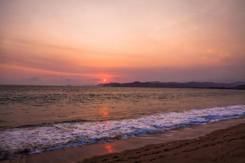 a sunset on the beach with the ocean at Hotel La Alondra in Barra de Navidad