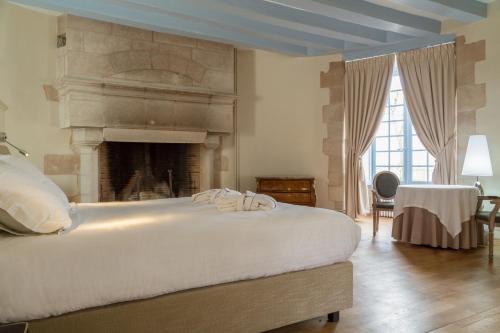 a bedroom with a large bed with a fireplace at The Originals le Château de Dissay Poitiers in Dissay