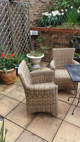 two wicker chairs and a table on a patio at 19 Upper Linney in Ludlow