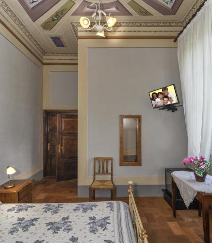 a bedroom with a bed and a table and a chair at B&B Villa Pardi Lucca in Lucca