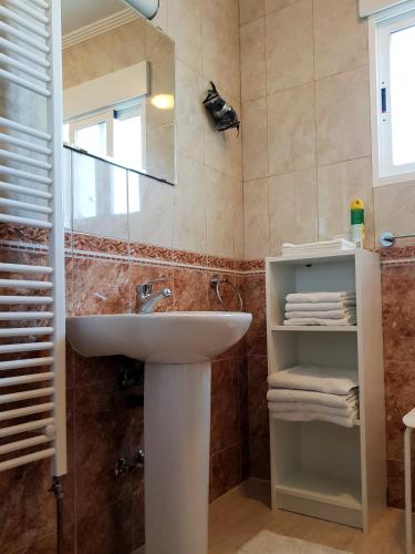 a bathroom with a sink and a mirror and towels at Villa Campos del Rio in Campos del Río