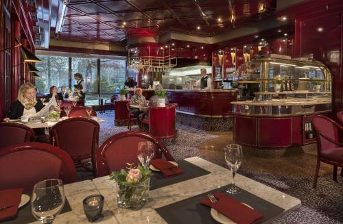 a restaurant with people sitting at tables and a counter at Maritim Hotel Bonn in Bonn