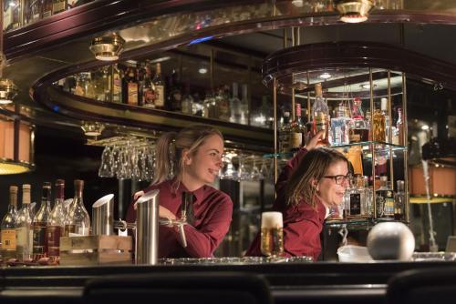 two women are sitting at a bar at Maritim Hotel Bonn in Bonn