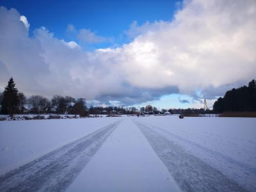 a snow covered road in a field at Jaunstūrīši in Ādaži