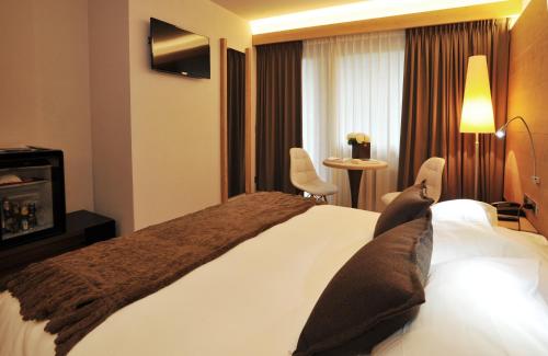 a hotel room with a large bed and a window at Palace Hotel Wellness & Beauty in Bormio