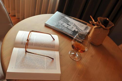 
a glass of wine sitting on a table next to a book at Palace Hotel Wellness & Beauty in Bormio
