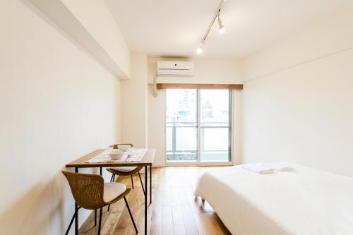 a bedroom with a desk and a bed and a window at Dwell Urban 7B in Tokyo