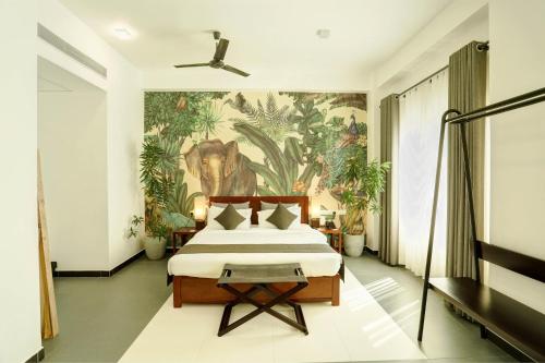 a bedroom with a bed with a painting on the wall at Morven Hotel Colombo in Colombo