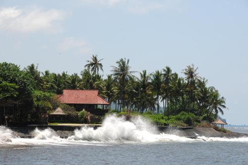 a house on the shore of the ocean with waves at Jasri Bay Hideaway in Jasri